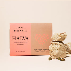 A box of cardamom halva with crumbled halva on the side.